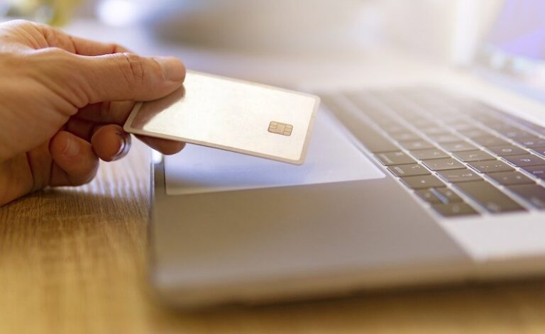una tarjeta de crédito y un ordenador portátil utilizados para comprar a una empresa de dropshipping