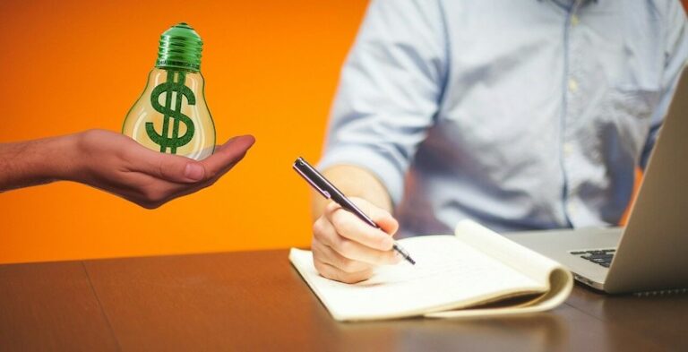 una persona escribiendo notas sobre cómo ganar dinero blogueando